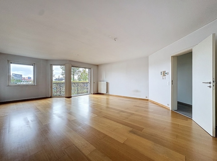 Espace lumineux et moderne avec sol en bois naturel et grandes fenêtres, idéal pour décoration minimaliste.