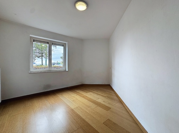 Espace minimaliste lumineux avec sol en bois clair, lumière naturelle, parfait pour création ou relaxation.