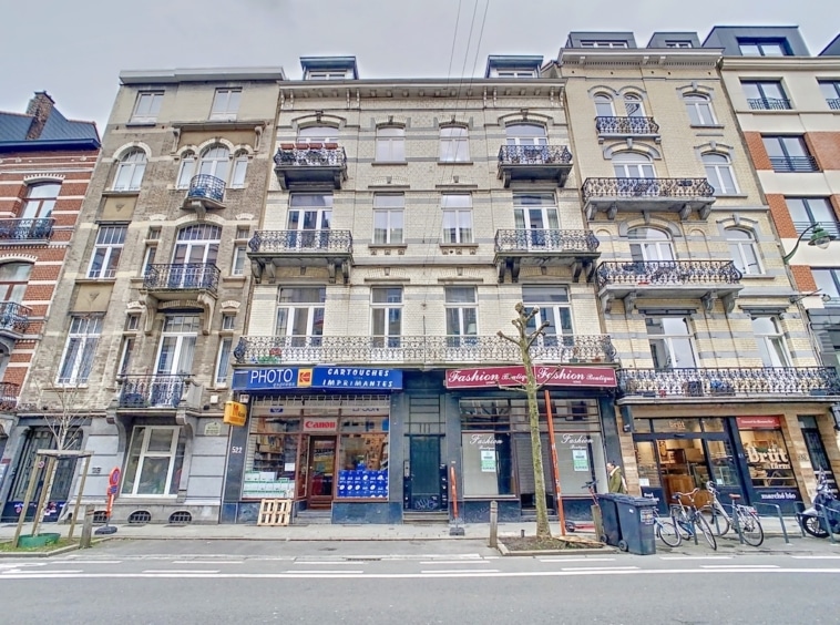 Quartier historique mêlant architecture classique, boutiques animées, vélos et bâtiments modernes sous ciel nuageux.