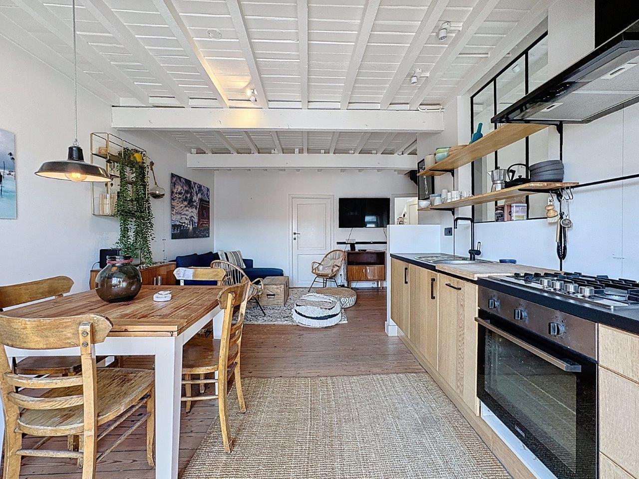 Salon cuisine moderne et lumineuse avec décoration maritime, mobilier chaleureux et ambiance conviviale