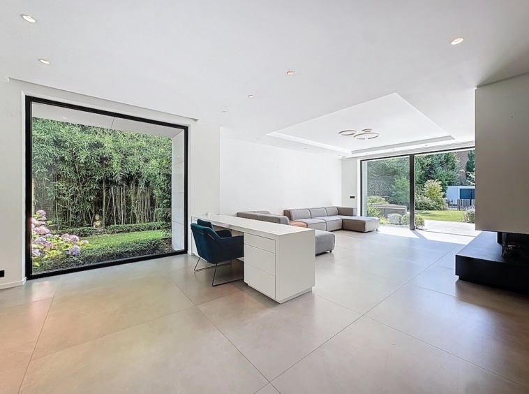 Salon moderne et lumineux avec vue sur jardin, mobilier épuré et ambiance chaleureuse.