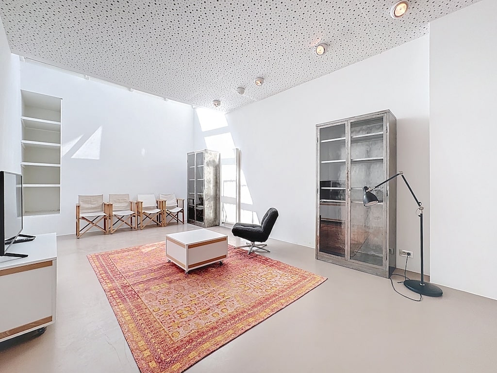 Salon moderne lumineux avec mobilier minimaliste, grandes fenêtres et ambiance chaleureuse.