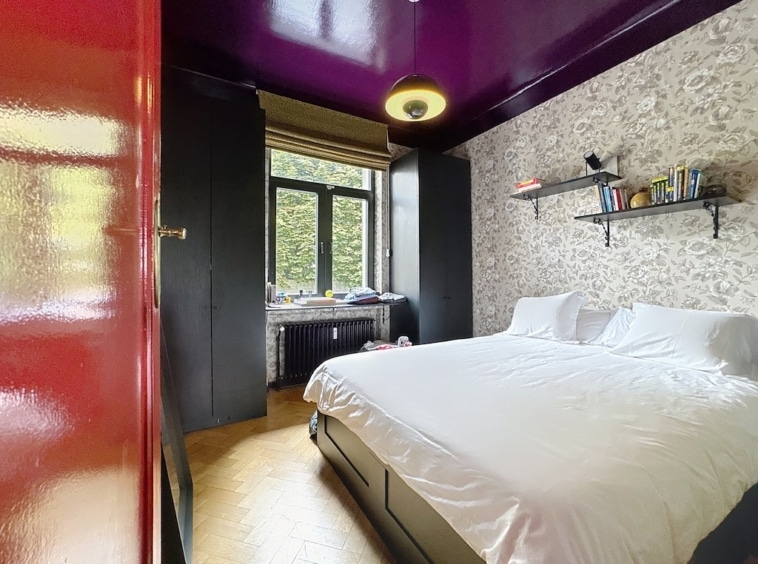 Chambre cosy moderne et vintage avec plafond violet, grande fenêtre et décoration élégante.