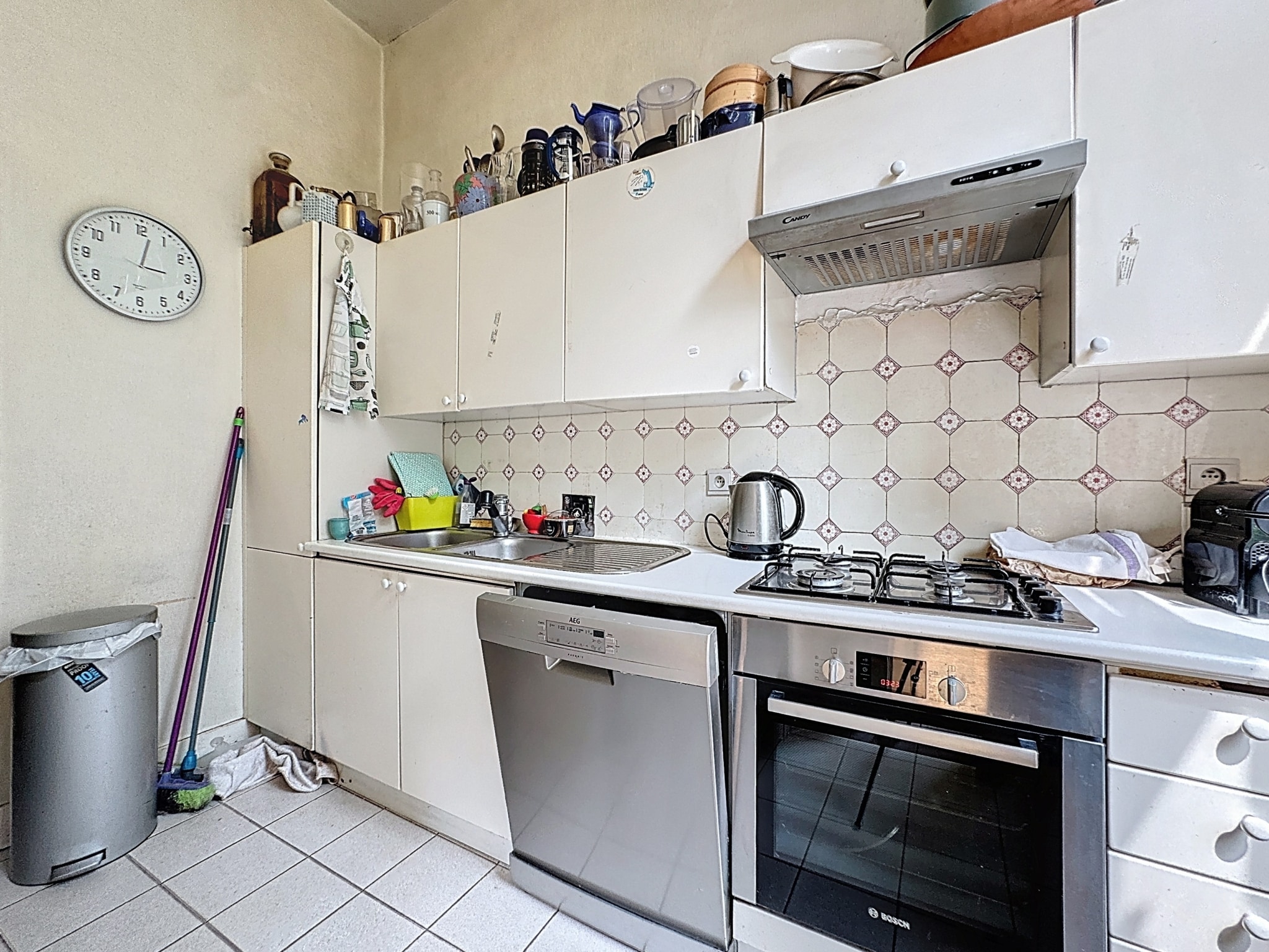 Cuisine chaleureuse avec meubles blancs, ustensiles colorés et ambiance conviviale.