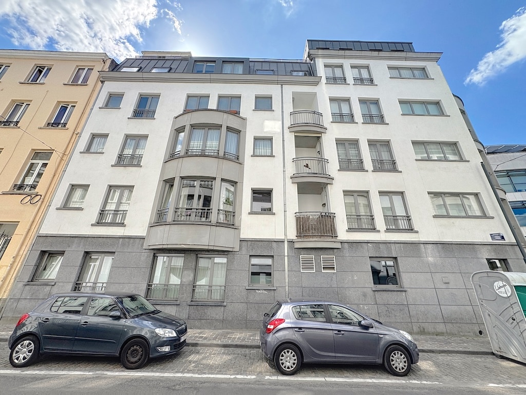Façade moderne avec bay window, balcon, grandes fenêtres, scène urbaine dynamique.