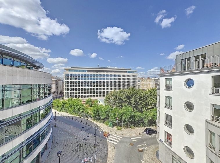 Ville moderne avec bâtiments innovants, espaces verts éclatants sous ciel ensoleillé.