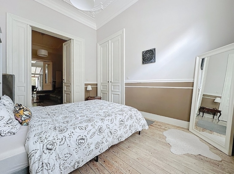 Chambre lumineuse et élégante avec murs bicolores, mobilier minimaliste et ambiance sereine.