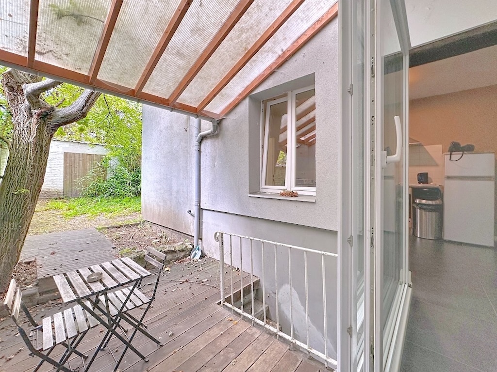 Petit patio en bois avec mobilier minimaliste, vue nature et ambiance chaleureuse.