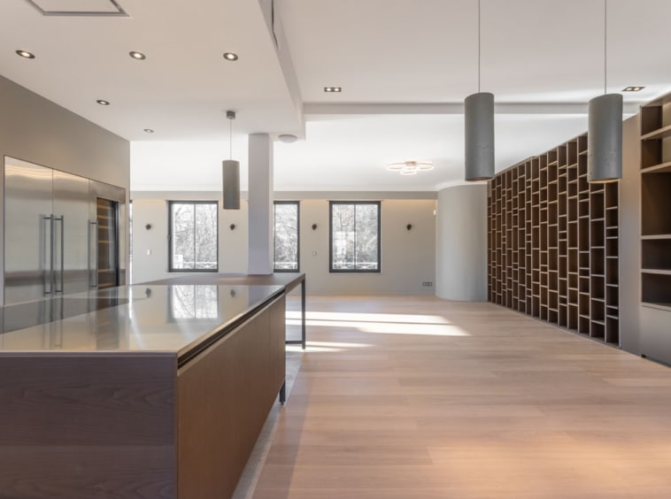 Interior lumineux moderne avec cuisine ouverte, bois chaleureux, mur en treillis, ambiance élégante et conviviale.