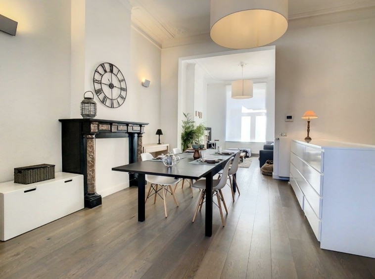 Salon moderne lumineux avec cheminée, mobilier épuré et éclairage design, ambiance chaleureuse.