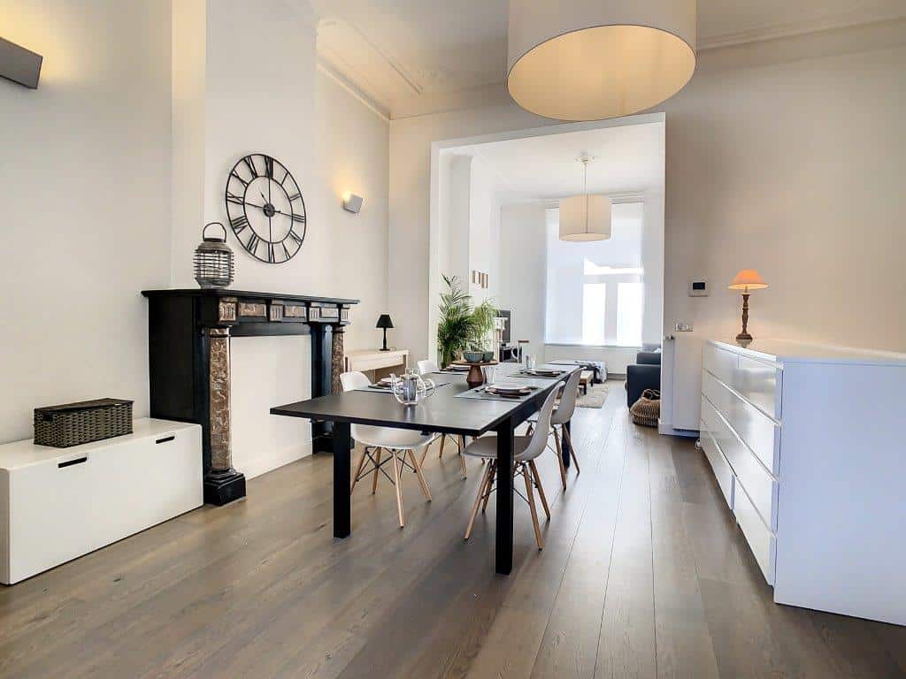 Salon moderne lumineux avec cheminée, mobilier épuré et éclairage design, ambiance chaleureuse.