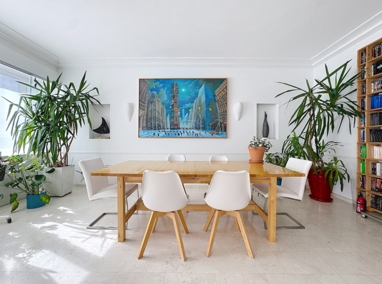 Salle à manger moderne avec plantes vertes et œuvre dart urbaine colorée.