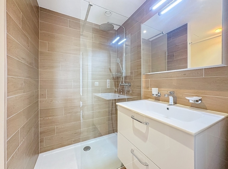 Salle de bain moderne en bois, verre et blanc, ambiance épurée et lumineuse.