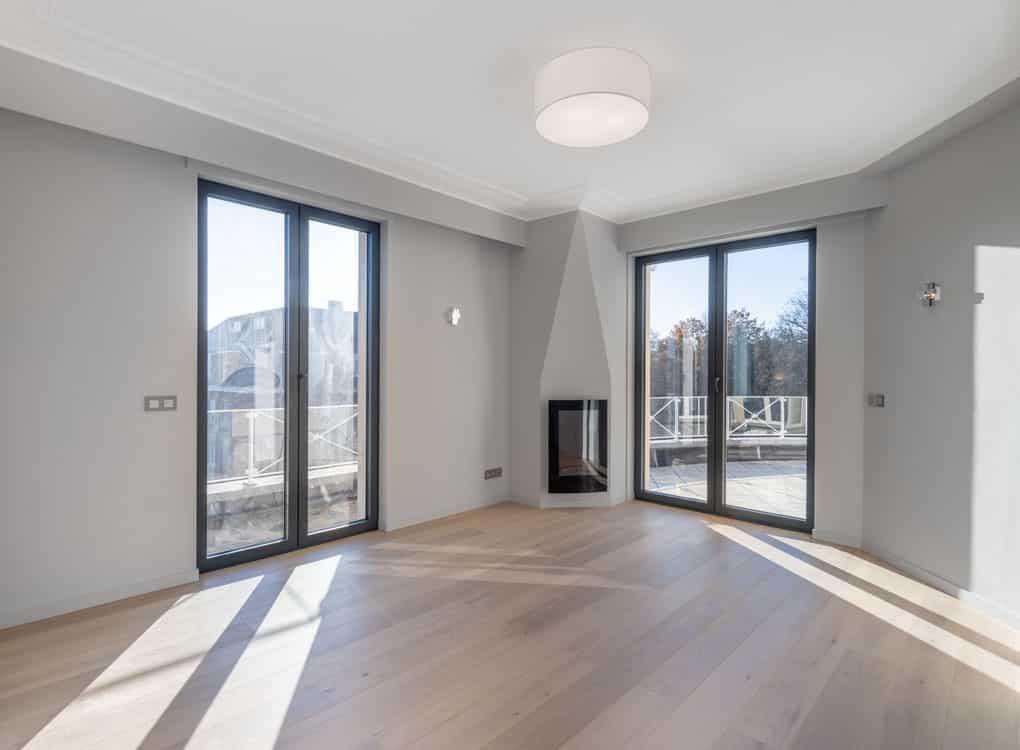 Salon moderne minimaliste avec grandes fenêtres, cheminée intégrée, ambiance lumineuse et chaleureuse.