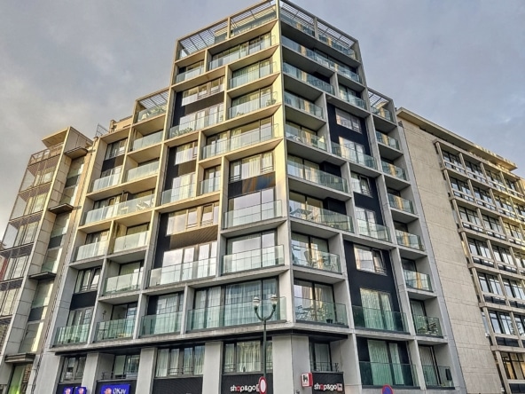 Immeuble moderne en verre et béton, avec balcons en urbanisme, ambiance lumineuse et dynamique.
