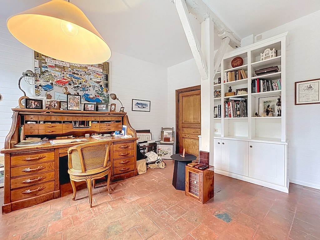 Gezellig vintage kantoor met houten meubels, boekenkast, fotomuur en daglicht.