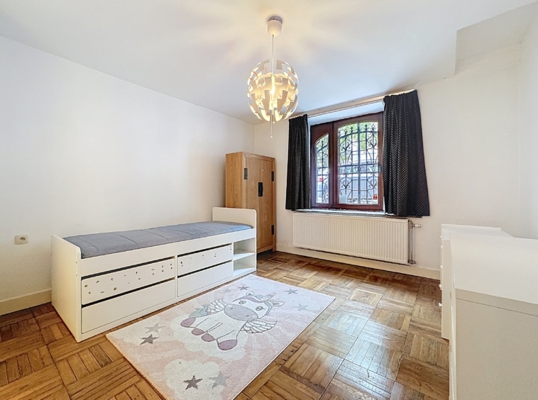 Chambre douce avec lit, armoire, tapis étoilé, licorne et éclairage moderne chaleureux.