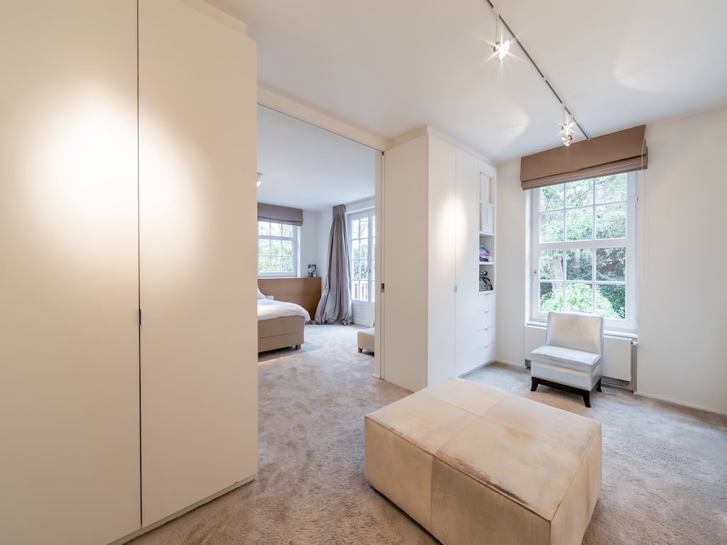 Chambre moderne et relaxante avec vue verdoyante, mobilier minimaliste et lumière naturelle apaisante.