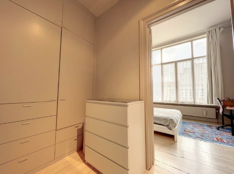 Chambre moderne avec rangement épuré, lumière naturelle, décor neutre et ambiance zen.