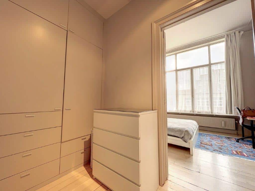Chambre moderne avec rangement épuré, lumière naturelle, décor neutre et ambiance zen.