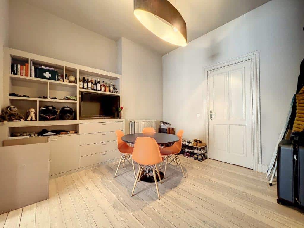 Salon moderne lumineux avec mobilier coloré, rangement intégré et ambiance chaleureuse.
