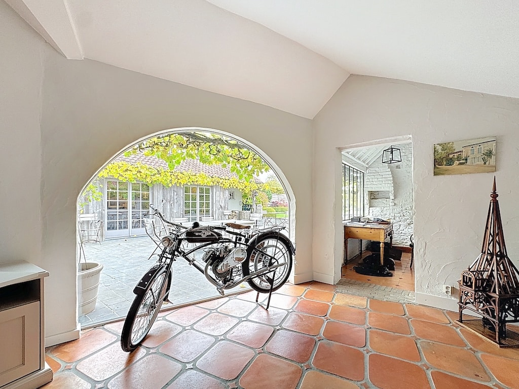 Lichte woonkamer met vintage motor, lommerrijke tuin, warme inrichting en gezellige sfeer.