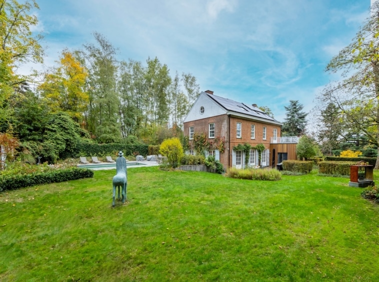 Gezellig bakstenen huis met tuin, paardensculptuur, zwembad en herfstsfeer.
