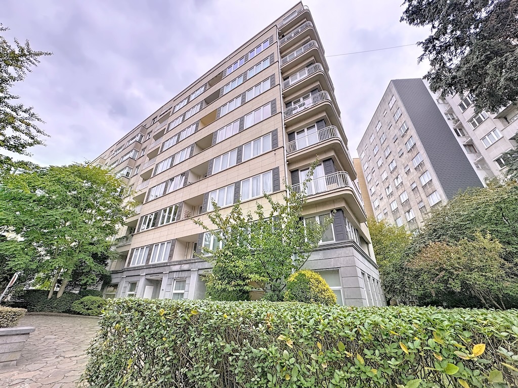 Résidence moderne avec balcons, large fenêtres et jardin verdoyant dans un quartier urbain serein