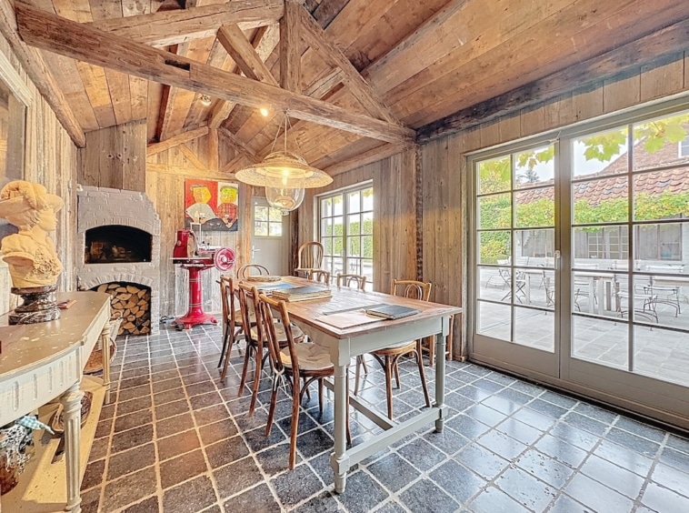 Warme, rustieke eetzaal met hout, natuurlijk licht, artistieke inrichting en vriendelijke sfeer.