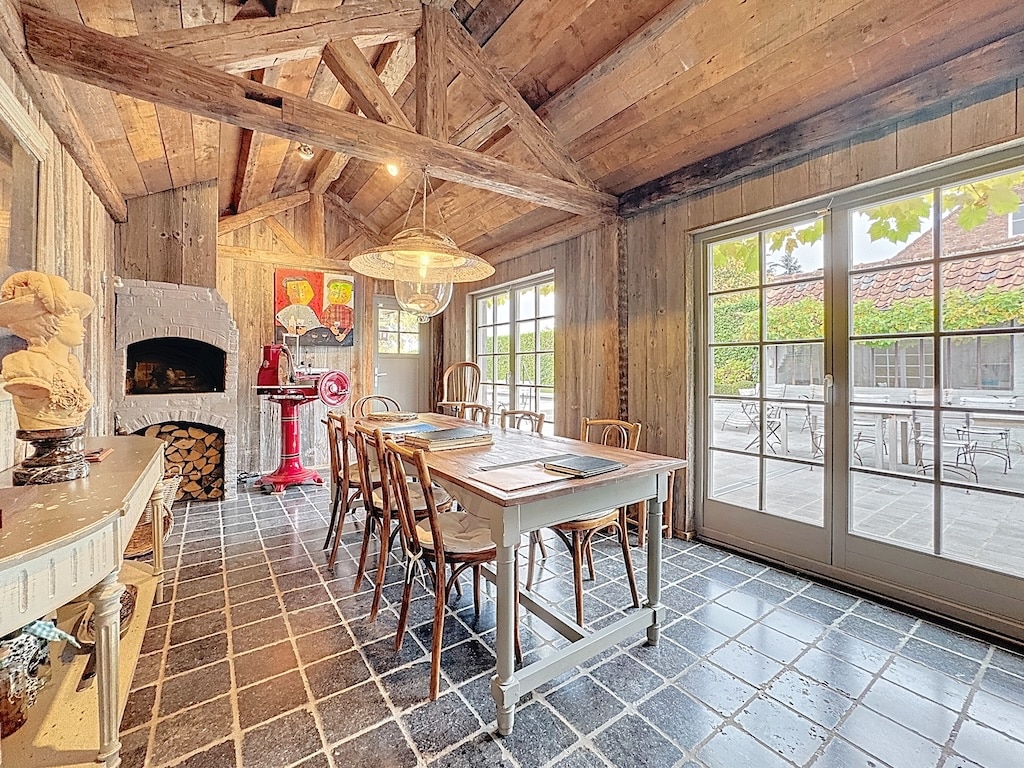 Warme, rustieke eetzaal met hout, natuurlijk licht, artistieke inrichting en vriendelijke sfeer.
