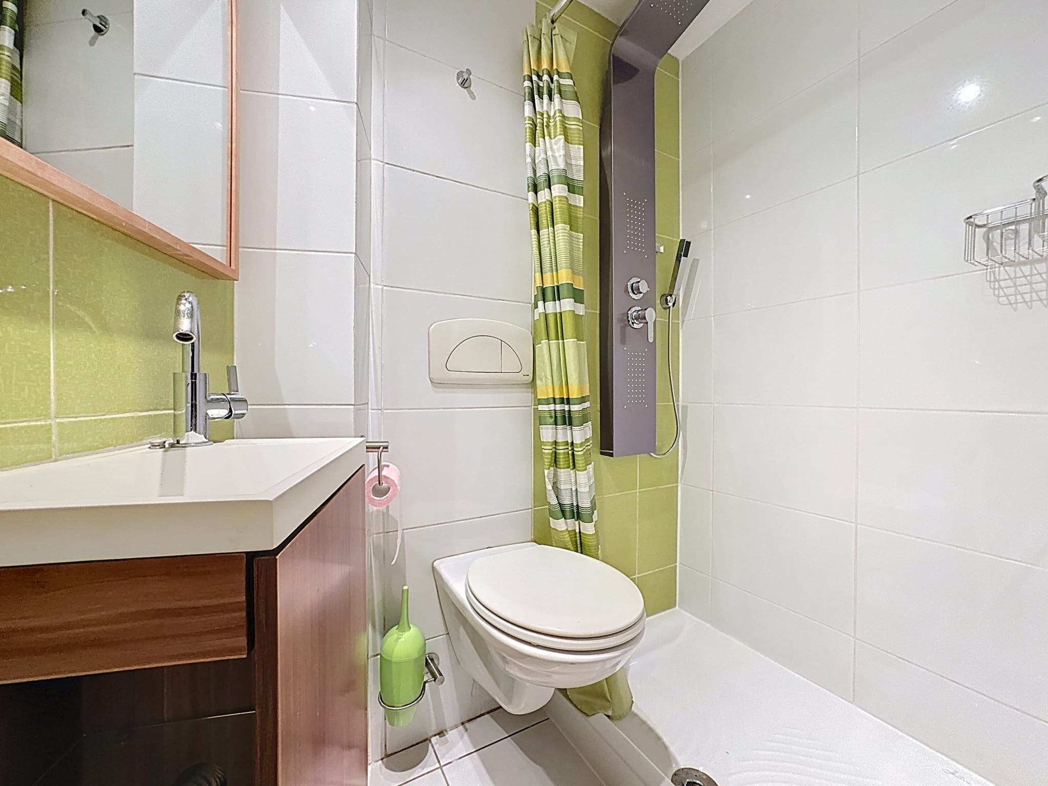 Salle de bain moderne avec accents verts, mobilier en bois naturel et design épuré pour relaxation.