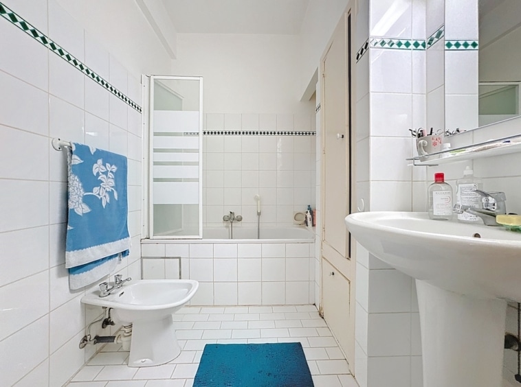 Salle de bain moderne, lumineuse, avec baignoire, lavabo, toilette et ambiance apaisante.