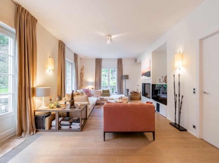 Salon lumineux, cosy et moderne avec canapé beige, décoration élégante et lumière naturelle.