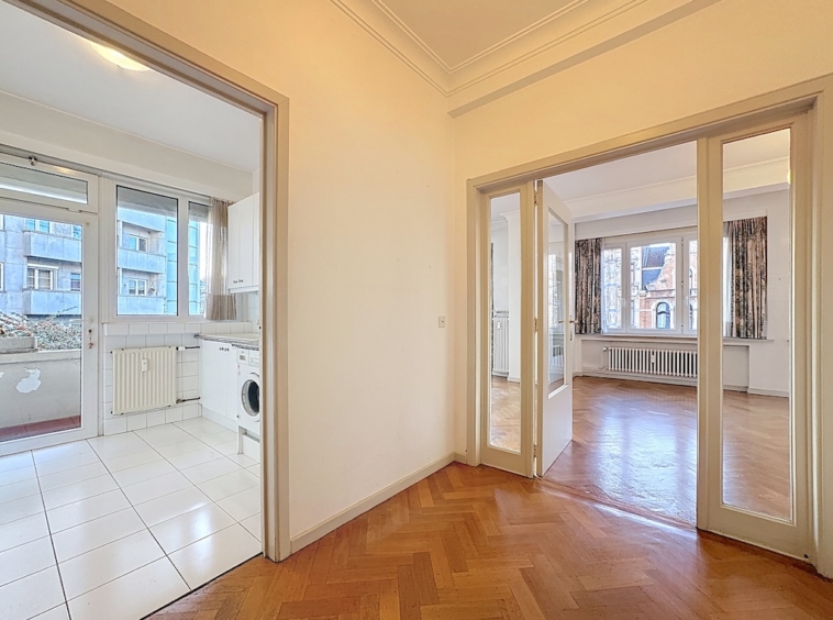 Salon et cuisine lumineux avec espace ouvert, parquet en bois et décoration moderne chaleureuse.