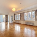 Salon spacieux lumineux avec parquet, grandes fenêtres, décoration élégante et ambiance chaleureuse.