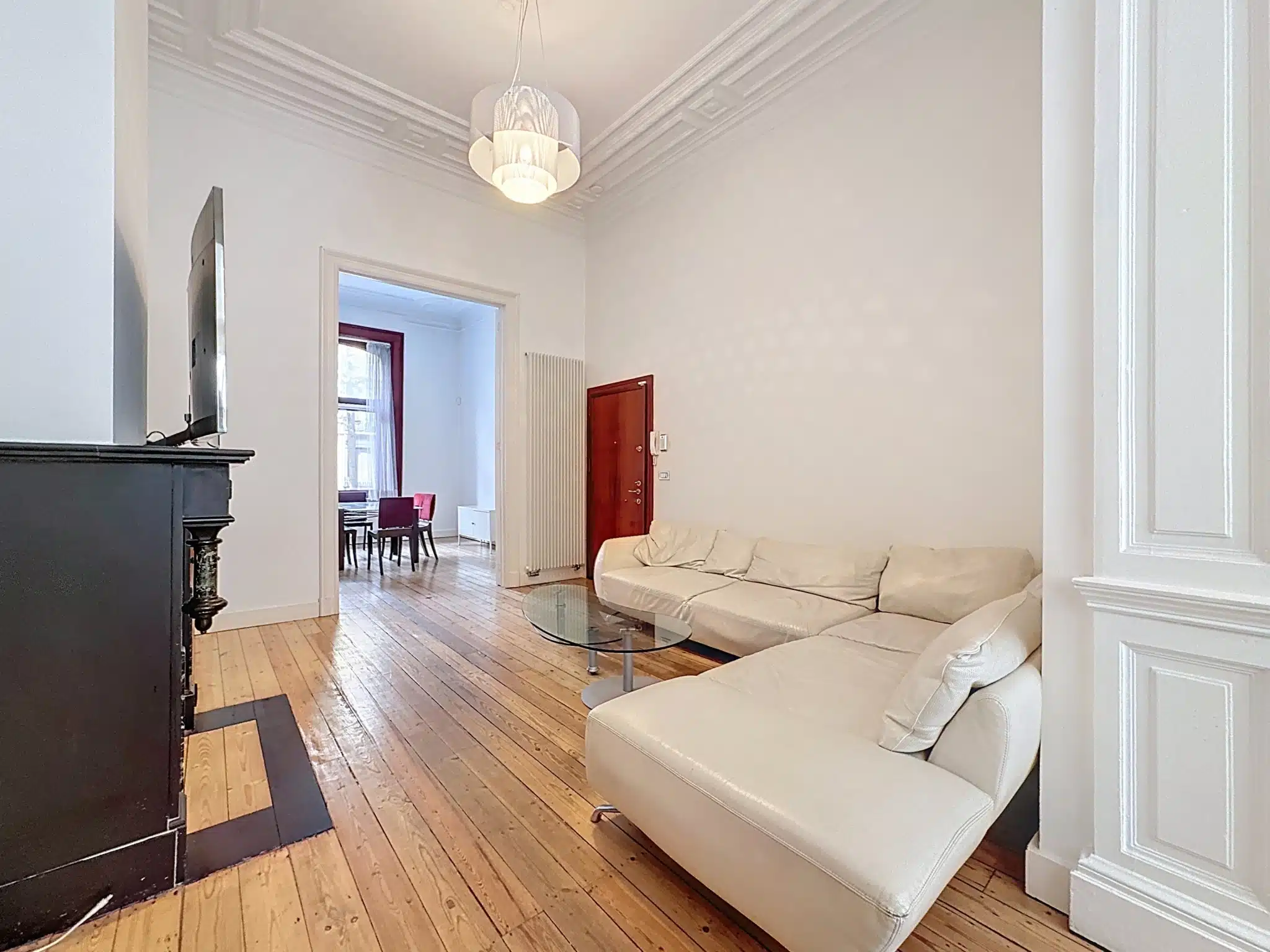 Moderne woonkamer met witte bank en designaccent Woonkamer - Licht duplex met tuin - Sint-Gillis