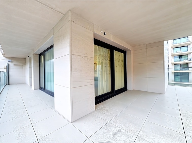 Balcon contemporain lumineux avec vue urbaine, sol en carrelage blanc, grandes portes en verre.slim