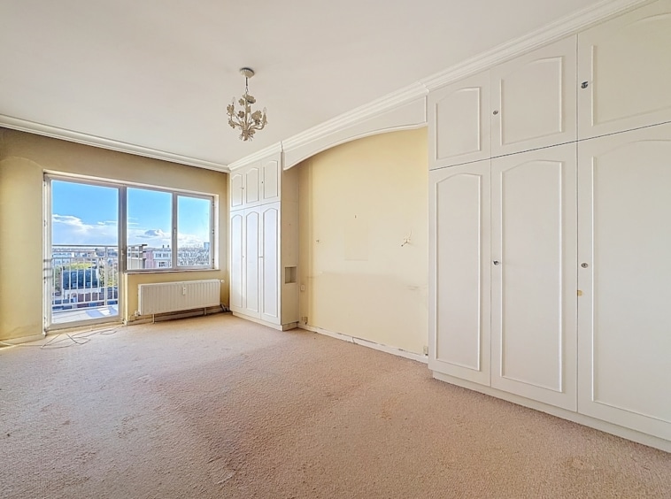Chambre lumineuse avec vue panoramique, décoration élégante, murs doux et mobilier minimaliste.
