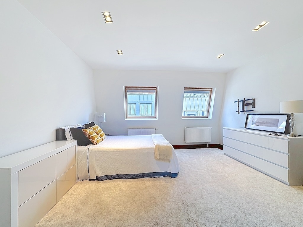 Chambre minimaliste moderne avec lumière naturelle, mobilier blanc, décor épuré et ambiance apaisante.