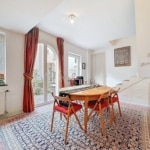 Coin repas chaleureux avec table en bois, lumière naturelle et décor élégant, idéal pour moments conviviaux.