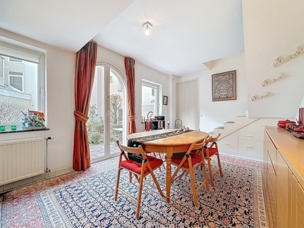 Coin repas chaleureux avec table en bois, lumière naturelle et décor élégant, idéal pour moments conviviaux.