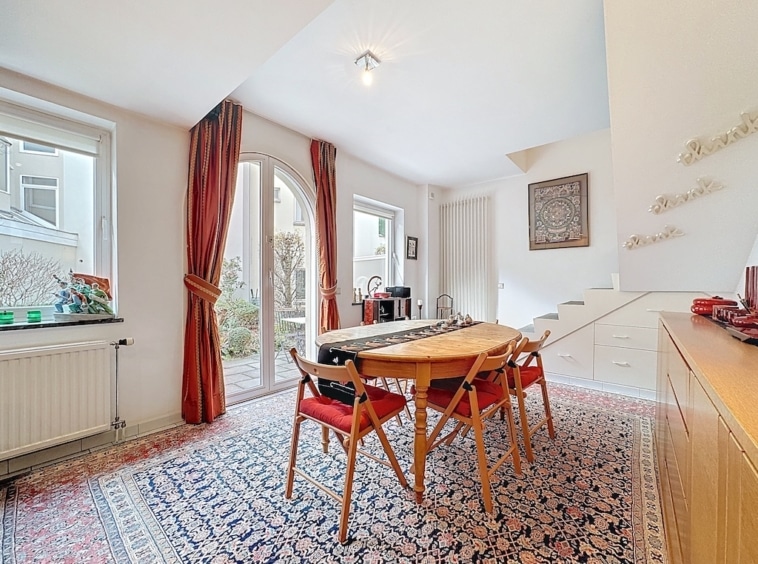 Coin repas chaleureux avec table en bois, lumière naturelle et décor élégant, idéal pour moments conviviaux.