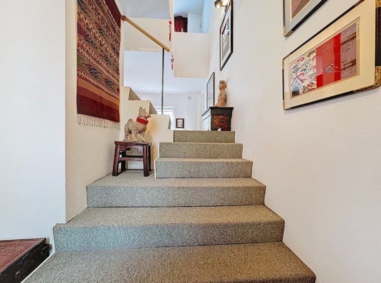 Escalier cosy, décor mural artistique, ambiance chaleureuse et accueillante dans une maison élégante.