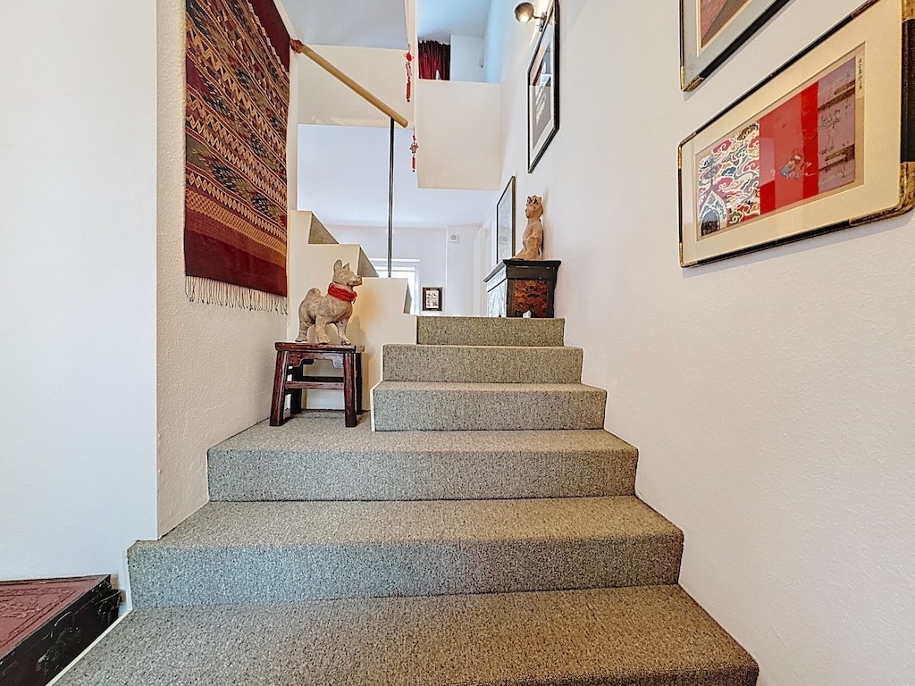 Escalier cosy, décor mural artistique, ambiance chaleureuse et accueillante dans une maison élégante.