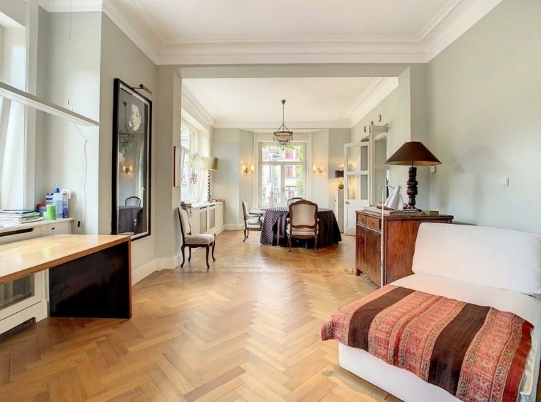 Salon lumineux avec mobilier moderne, murs pastel verts, espace repas cosy, ambiance élégante et chaleureuse.