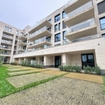 Appartement moderne avec balcons, jardin soigneusement aménagé et façade élégante en pierre claire.
