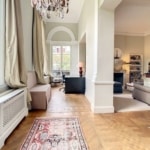 Salon moderne avec espace de travail, canapé cosy, tv, décoration élégante, lumière naturelle abondante.