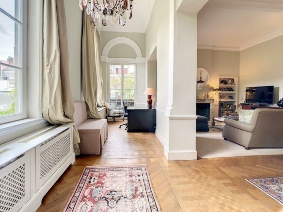 Salon moderne avec espace de travail, canapé cosy, tv, décoration élégante, lumière naturelle abondante.