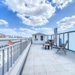 Terrasse urbaine moderne avec vue, mobilier minimaliste, parasol, ambiance paisible et panoramas urbains.