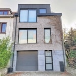 Maison moderne avec briques claires grandes fenêtres panoramiques et contraste architectural élégant